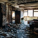 Burnt house interior. Burned room in industrial building, charred furniture and damaged apartment after fire, toned